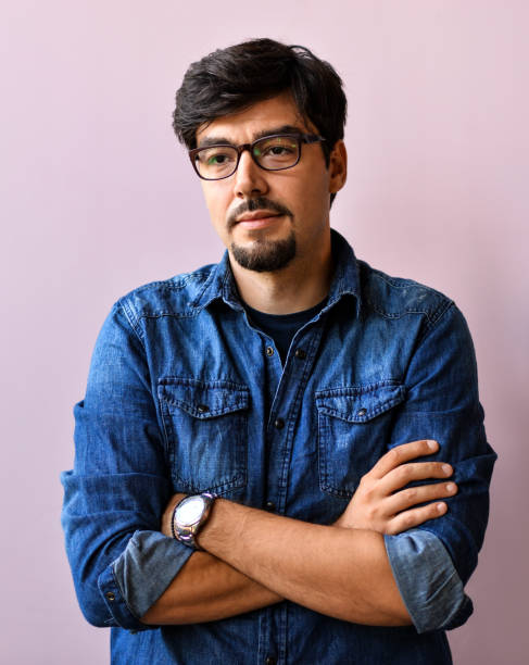 istock Young man in blue shirt over pink background 1166397802