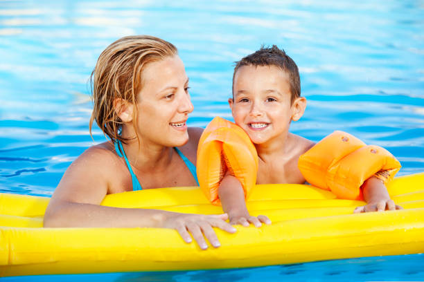 istock Family having fun in the swimming pool 1166398480
