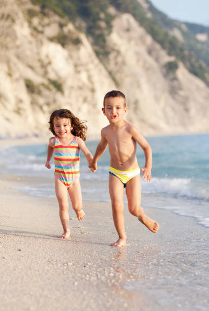 istock Children running at the beach 1166398529