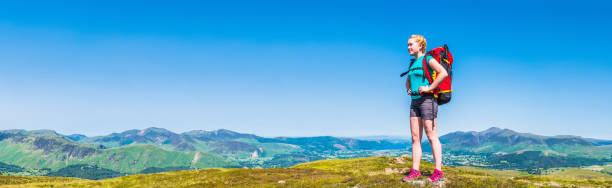 istock Young woman hiker backpack on mountain overlooking panoramic summer view 1166399132