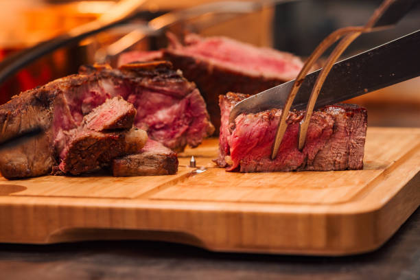 istock Cutting juicy medium beef steak, close-up. 1166399263