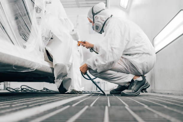 istock Painter in protective work wear painting car body, low angle image 1166399318