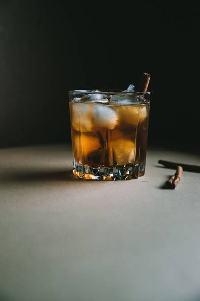 istock Whiskey with ice cubes and cinnamon stick on dark background 1166399595