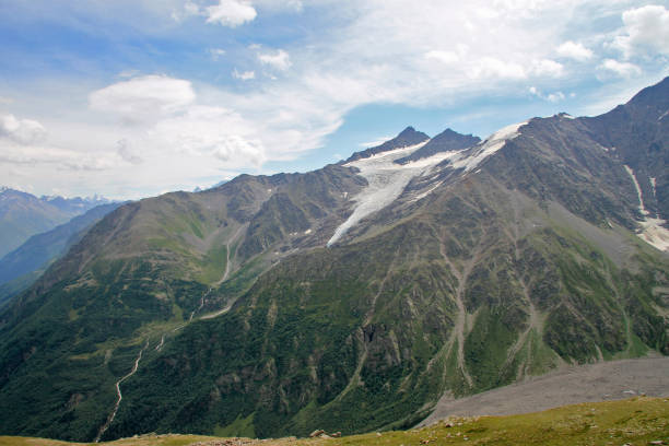 istock Caucasus mountains summertime under blue sky and white clouds. North Caucasus landscape in august mounth, Russian Federation 1166399748