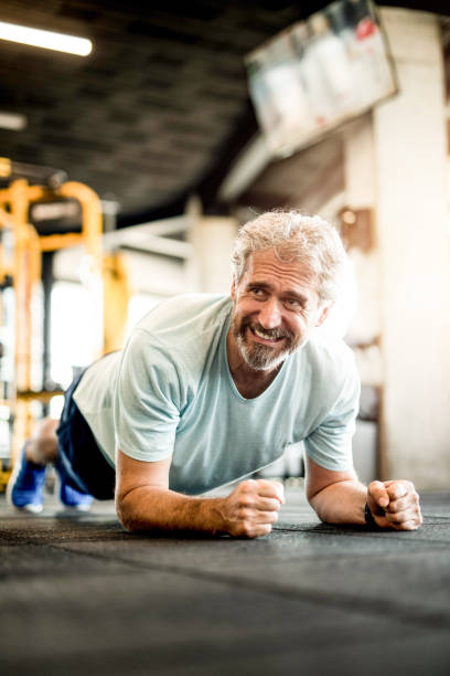istock Mature man doing strength exercises in a gym. 1166400112