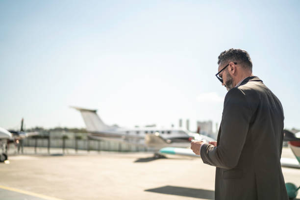 istock Businessman using smartphone walking in hangar 1166401495