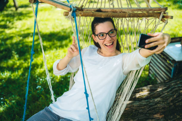 istock Woman sitting in hammock chair 1166403955