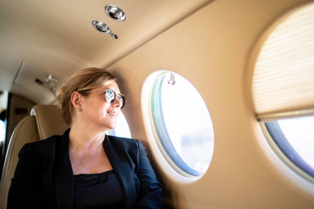 istock Businesswoman looking through airplane window 1166403999