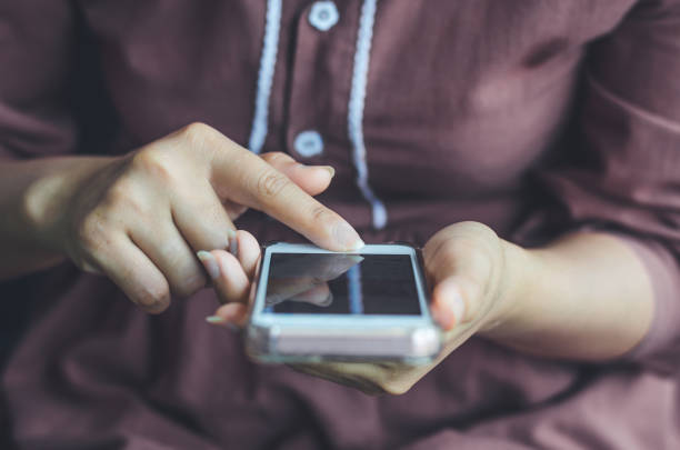 istock hipster woman using hands touching and typing on mobile phone screen search internet online working or social communication with digital 5G technology app device in coffee shop indoor lifestyle. 1166404104