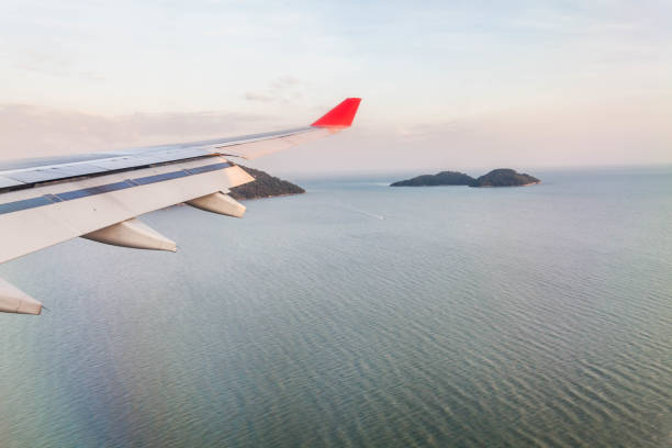 istock Plane wing view from inside plane in midair with blue sky cloud background 1166404692