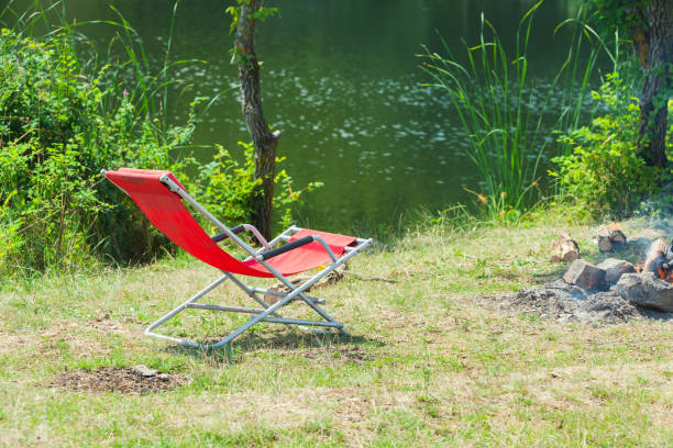 istock Empty red folding travel chair near bonfire 1166409125