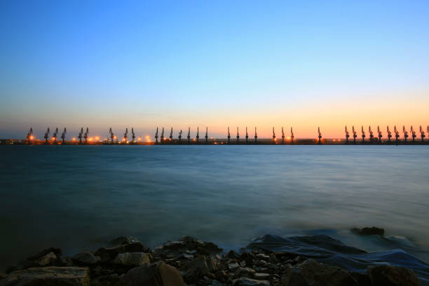istock Gantry crane and cargo ship in the evening, Shipping and logistic concept 1166411545