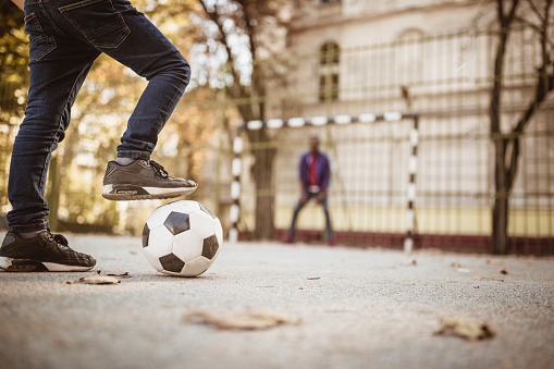 Father and son playing soccer, outdoors