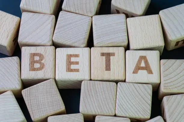 Beta coefficient or measure of volatility and risk of an individual stock compare to unsystematic risk in stock market concept, cube wooden block with alphabet combine the word Beta.