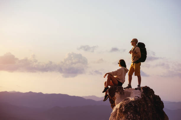 istock Couple backpackers on big rock at sunset 1166417441