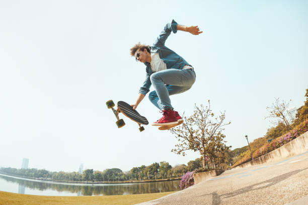istock Hipster jumps with skateboard in park 1166417823
