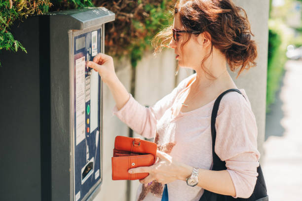 istock Young woman paying for parking with coins 1166419155