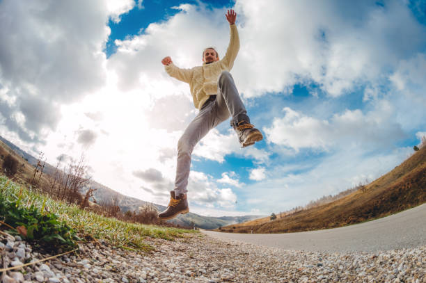 Man jumping next to a country road