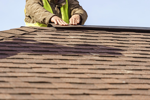 Trabajador instalar elemento de techo de teja en nueva casa en construcción photo