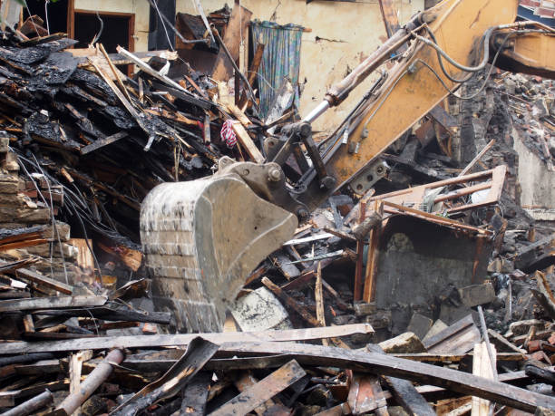 istock Hydraulic crusher excavator backoe machinery working on a demolition site clearing debris 1166423056