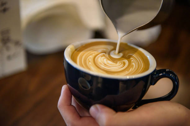 istock Barista make coffee froth art on black cup 1166425780