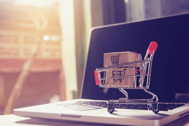 online-shopping-konzept - paket- oder papierkartons mit einkaufswagen-logo in einem trolley auf einer laptop-tastatur. shopping-service auf dem online-web. bietet hauslieferung. - hardware store store shopping cart shopping stock-fotos und bilder