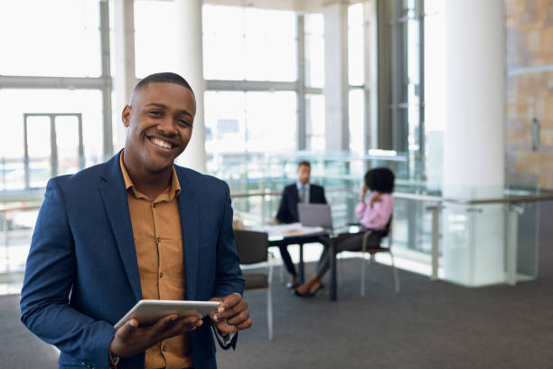 istock Young businessman looking to camera standing in an office 1166429630