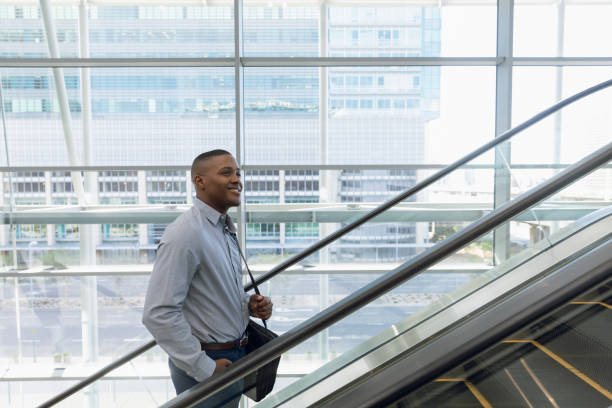 istock Smiling businessman going up an escalator 1166434742