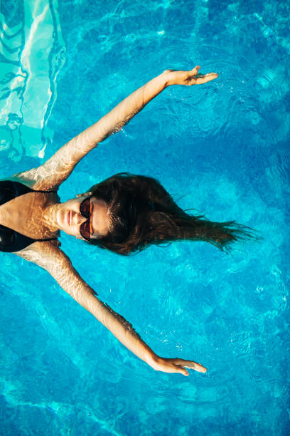 istock Woman Floating at Swimming Pool 1166434916