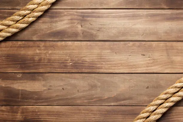 Photo of ship rope at wooden board background