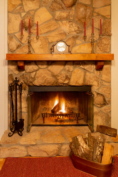 istock Glowing fire in a stone fireplace with wooden mantle. 1166435542