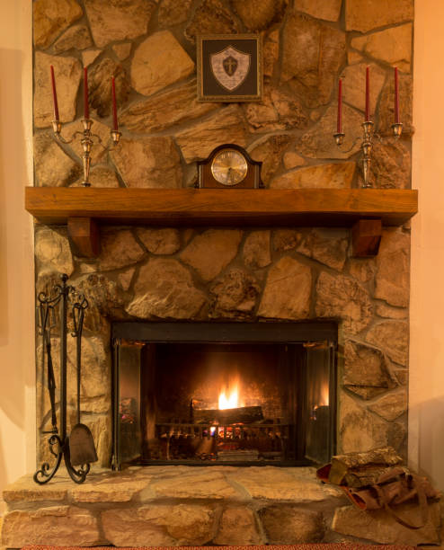 istock Glowing fire in a stone fireplace with wooden mantle. 1166436180