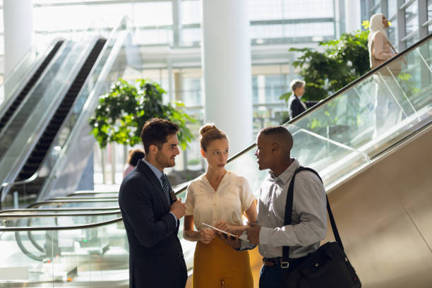 istock Diverse young business people with tablet talking in a modern atrium 1166436411