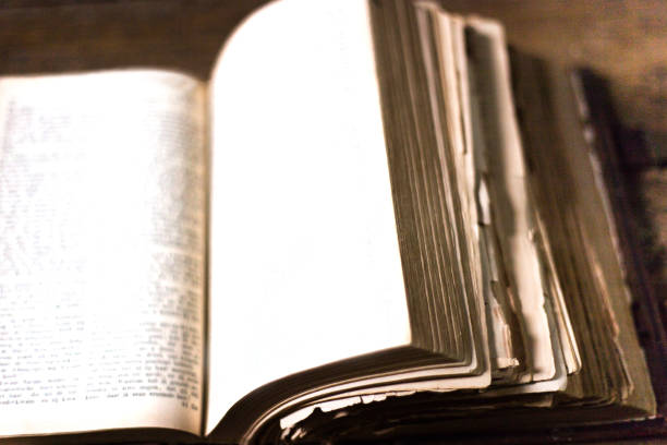 istock Antique Worn and Torn Open Book, Brown Wood Background 1166436927