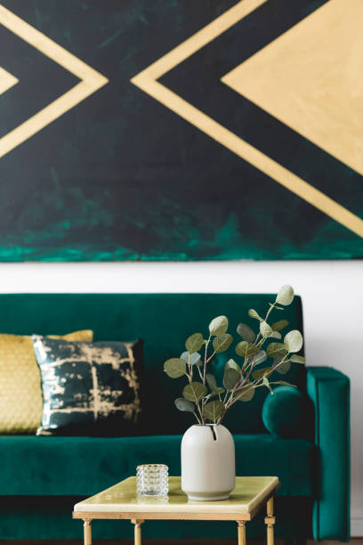 istock Luxury composition of home interior design with modern velvet sofa, marble coffee table, pillows, flowers elegant accessories and geometric paintings on the wall. Stylish home decor. Template. 1166437852