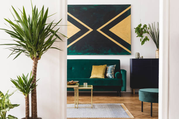 istock Luxury and modern composition of home interior design with design velvet sofa, pouf, shelf, pillows, coffee table, tropical plants and elegant accessories. Stylish home decor. Template. 1166437854