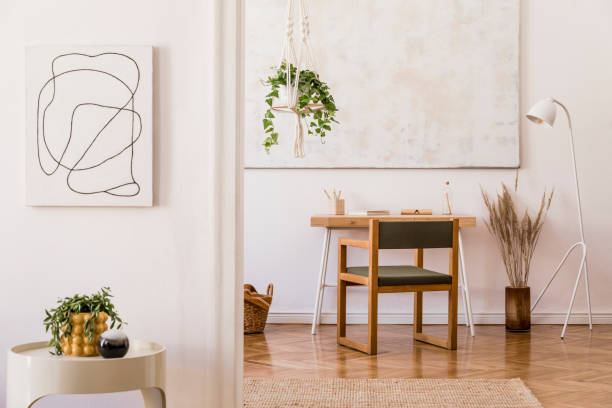 istock Minimalistic boho interior with design wooden desk, armchair, lamp, white coffee table with plant, flovers and elegant accessories. Mock up poster frame on the wall. Stylish home decor. Template. 1166439081