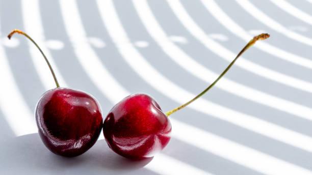 istock cherry on white background illuminated by the rays of the sun 1166439264