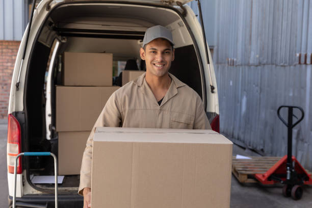 istock Delivery man carrying cardboard boxes outside the warehouse 1166439347