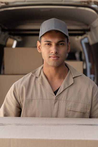 istock Delivery man carrying cardboard boxes outside the warehouse 1166439367