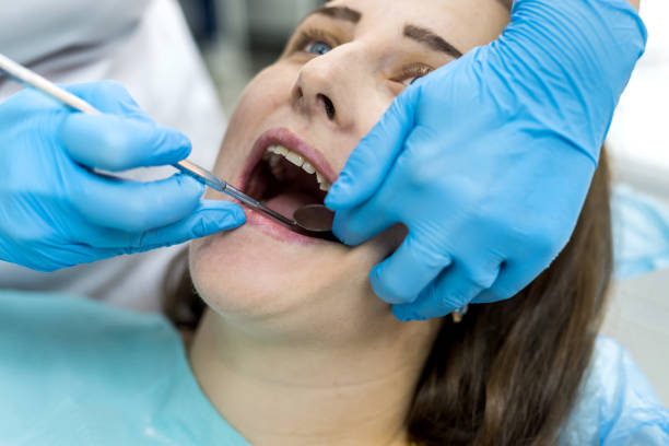 istock Dentist's hands in gloves with instrument and patient 1166440053