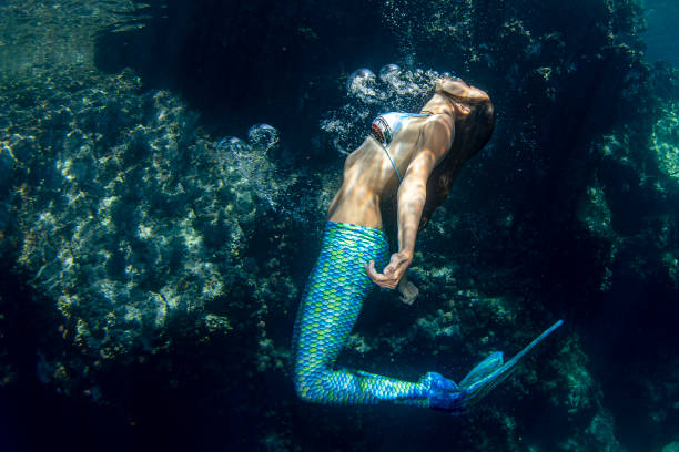 istock Mermaid swimming underwater in the deep blue sea 1166441028