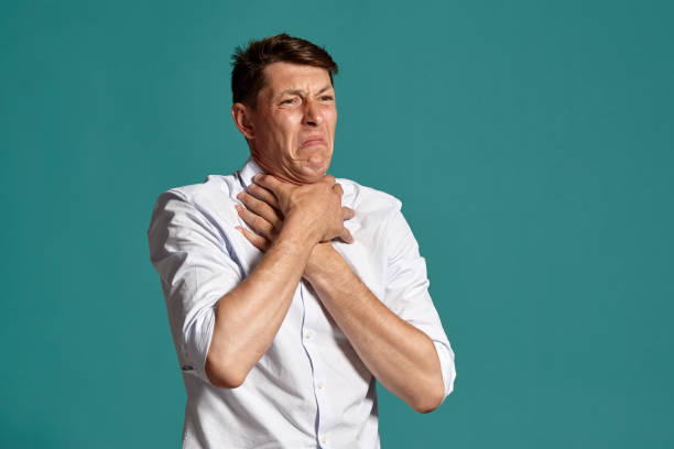istock Young man in a classic white shirt is posing over a blue background 1166441125