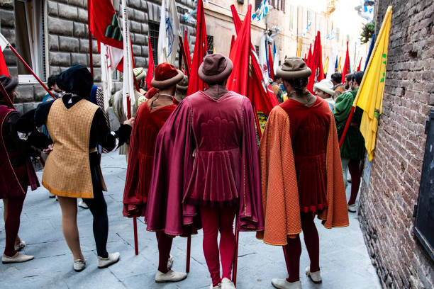 Legs of men in medieval clothing at Palio parade Siena, Italy - July 2, 2019: Legs of men from behind in medieval clothing and tights at Palio parade cirque de soleil stock pictures, royalty-free photos & images