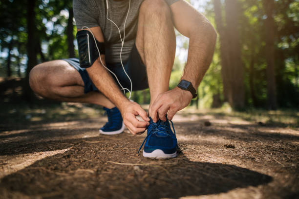 istock Sports man tying shoes while running 1166446937