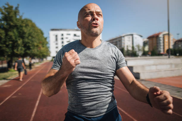 istock Mature man sprinting on a running track 1166448313