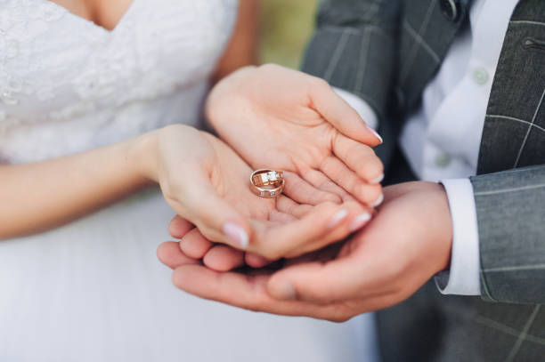 istock Two wedding rings on bride and groom's palms. Close-up. 1166448742