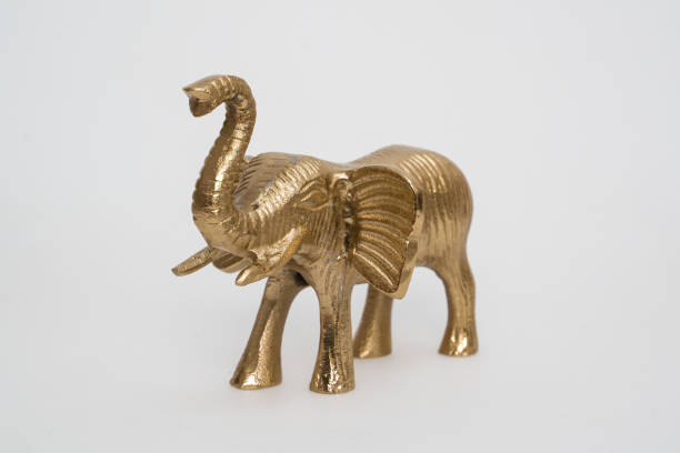 istock Golden elephant statuette with raised trunk isolated on white background. 1166454459