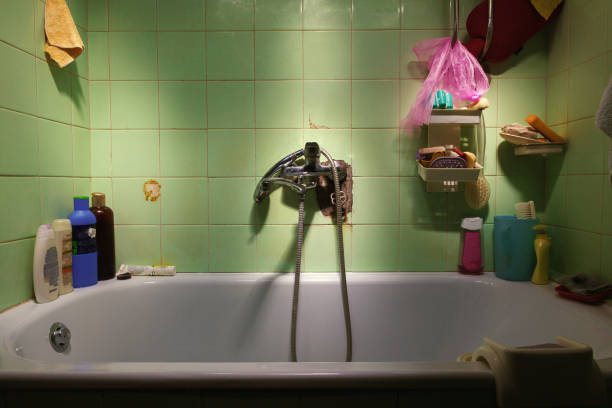 Details of an old bathroom, tub and accessories, dirty and old tiles.