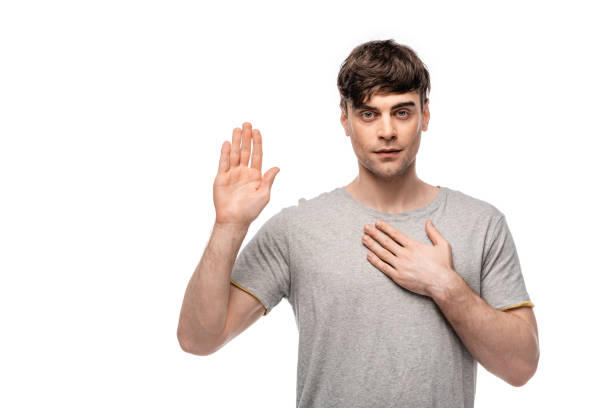 istock serious young man looking at camera while showing swear gesture isolated on white 1166455290